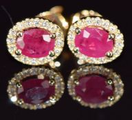 A pair of 18ct gold earrings each set with a 0.5ct ruby surrounded by diamonds, 1.6g