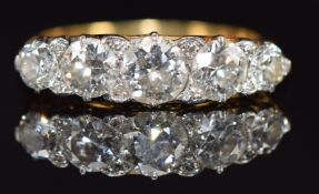 An 18ct gold ring set with five old cut diamonds and eight rose cut diamonds, the centre diamond