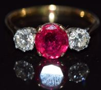 An 18ct gold ring set with an oval cushion cut synthetic ruby approximately 1.6ct and two diamonds