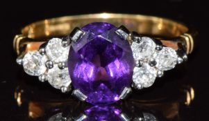An 18ct gold ring set with an oval cut amethyst and six old cut diamonds in a platinum setting, 4.