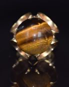 A 9ct gold ring set with a tiger's eye cabochon, London 1972, 10g, size J