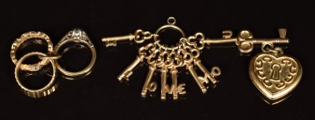 Three 9ct gold charms / pendants comprising heart padlock, keys and rings, 7.6g