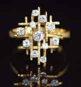 A 1970s 18ct gold ring set with diamonds in a tiered setting the largest diamond approximately 0.
