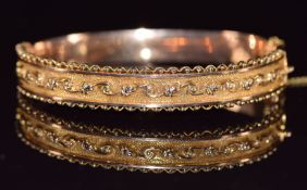 A 9ct gold bangle with scrolling decoration, Birmingham 1915, 9.8g