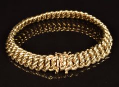 A 9ct gold bracelet made up of oval twist links with engraved decoration to the border, 20.2g