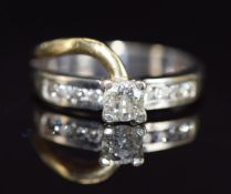 An 18ct gold bi-coloured ring set with a round cut diamond of approximately 0.4ct, with further