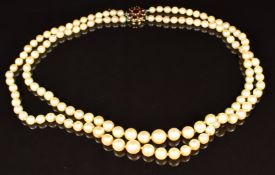 A double strand of cultured pearls, the 9ct gold clasp set with garnets