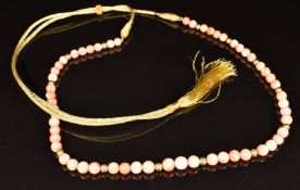 A beaded coral necklace and ridged gold beads