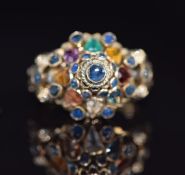 An 18K gold ring set with sapphires, garnet, tiger's eye, citrine, topaz etc in a domed cluster, 4.
