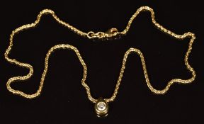 An 18ct gold pendant set with a round cut diamond of approximately 0.22ct, on an 18ct gold chain,