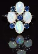 An 18k white gold ring set with four oval opal cabochons and five sapphires, 3.6g, size P