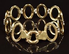 A 14k gold bracelet made up of oval links and white gold spheres, 13.2g