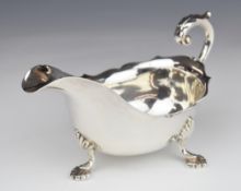 George V hallmarked silver sauce boat with scroll handle, raised on three feet, Birmingham 1931,