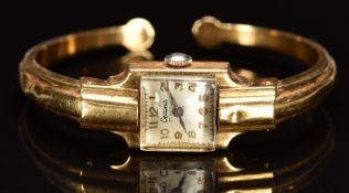 Optima 18ct gold ladies bangle wristwatch with blued hands, gold Arabic numerals, silver dial and 17