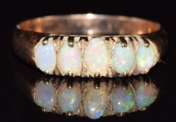 A 9ct rose gold ring set with five opals, 1.7g, size N