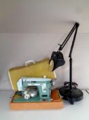 A 20th century New Home electric sewing machine in case together with an angle poise magnifying