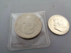 An American 1776-1976 dollar together with a 1954 half dollar