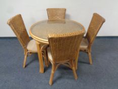 A circular bamboo and wicker glass topped conservatory table together with four chairs