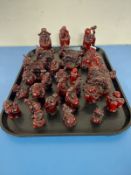 A tray containing approximately twenty-seven oriental resin figures of seated buddhas, sages,