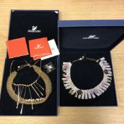 Three Swarovski necklaces, in two boxes.