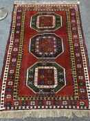 A Caucasian design rug on red ground,