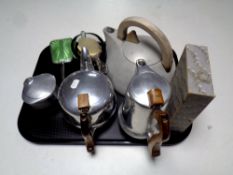 A tray containing a three piece Picquot Ware teapot, together with a further cast iron teapot,