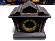 An antique black slate and marble mantel clock