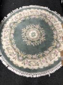 A circular Chinese rug on green ground,