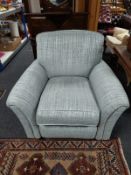 A contemporary armchair in grey upholstery