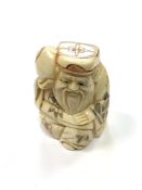 A Chinese bone netsuke - A Village Elder Carrying Fruit.