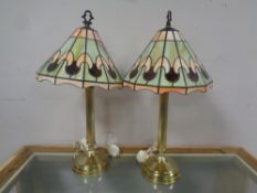 A pair of brass column table lamps with leaded glass shades