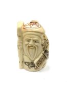 A Chinese bone netsuke - A Beaded Man Holding a Stick.
