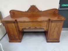 A mahogany break front twin pedestal sideboard