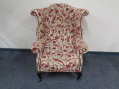 A wingback armchair upholstered in a floral fabric