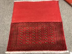 An eastern fringed cushion cover on red ground,