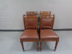 A set of four Edwardian mahogany dining chairs upholstered in a studded leather