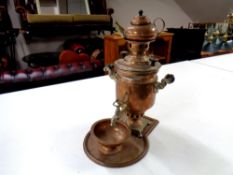 An antique copper tea urn on tray with kettle