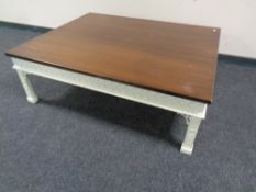 An oversized low coffee table on painted legs,