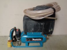 A Makita 110 V compressor with hose