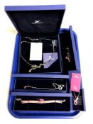 A tray containing five pieces of Swarovski jewellery to include pendants on chains, bracelet,