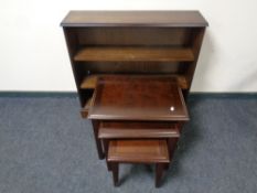 A nest of three contemporary tables together with a set of bookshelves in an oak finish