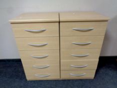 A pair of five drawer chests in a pine finish
