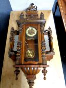 An antique Vienna wall clock with brass dial and pendulum