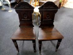 A pair of late 19th century carved oak hall chairs