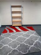 A set of contemporary open shelves together with two woolen rugs