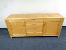 An Ercol oak Basco double door sideboard fitted four central drawers,
