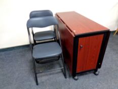 A drop leaf storage kitchen table containing six folding chairs