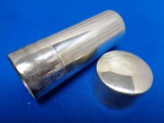 A silver cylindrical coin holder