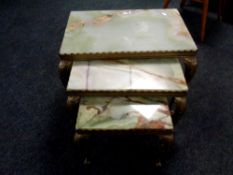 A nest of three gilt metal and onyx tables