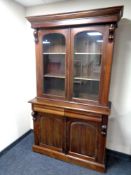 A Victorian style glazed double door bookcase fitted cupboards and drawers beneath